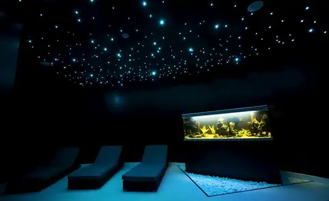 Sala de relax con techo de estrellas, tumbonas y acuario en el spa del Hotel Bienestar Moaña