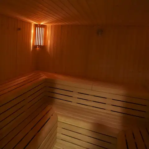 Sauna de madera con bancos escalonados y luz cálida en el spa del Hotel Bienestar Moaña