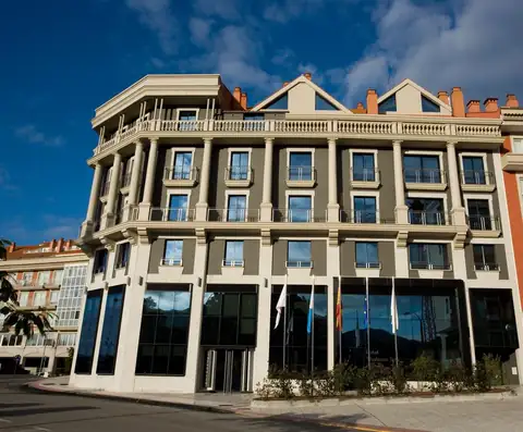 Fachada del edificio clásico con banderas en la entrada del Hotel Bienestar Moaña