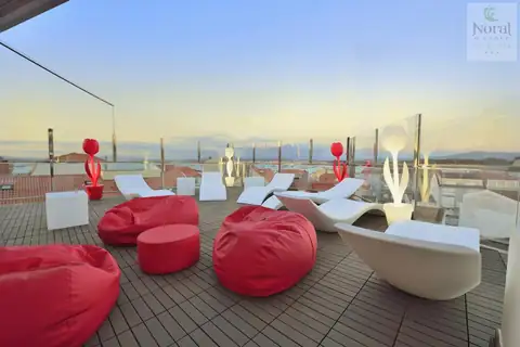Azotea chill out con puffs rojos y tumbonas de diseño al atardecer en el Hotel Spa Norat O Grove