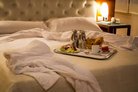 Desayuno servido en bandeja sobre la cama de una habitación del Exe Vía Argentum