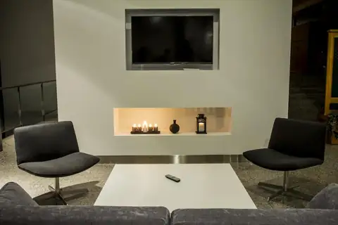 Rincón de descanso con sillones, mesa baja y televisor en el Exe Vía Argentum