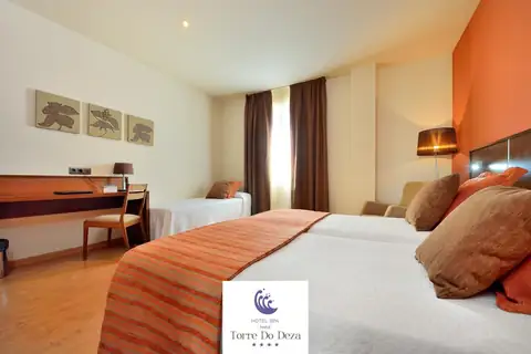 Habitación con dos camas, colchas a rayas y escritorio en el Hotel Spa Norat Torre do Deza