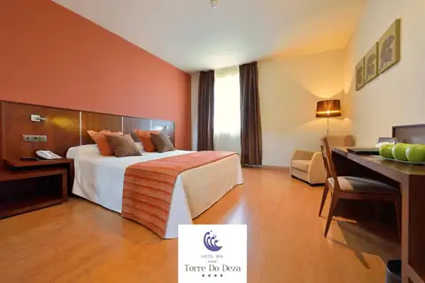 Habitación doble con escritorio, butaca y lámpara de pie en el Hotel Norat Torre do Deza