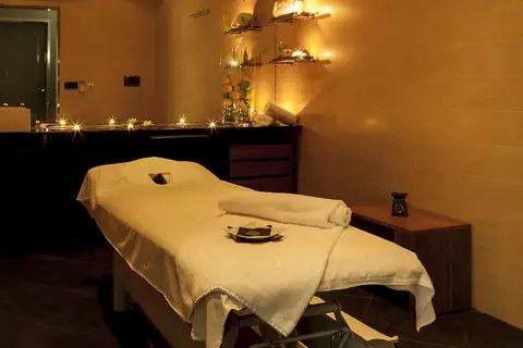Cabina de masajes con camilla y luz de velas en el balneario del Eurostars Vila de Allariz