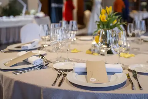 Mesa de banquete con copas, centro de tulipanes amarillos y minutas en el Eurostars Vila de Allariz