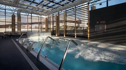 Piscina de hidroterapia con chorros y lamas de madera en Termaria Casa del Agua