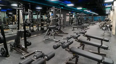 Sala de musculación con bancos y máquinas de pesas en Termaria Casa del Agua