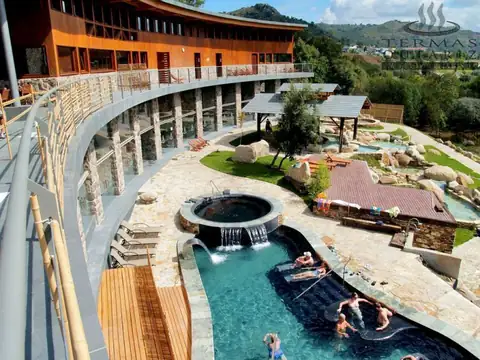 Vista elevada de las piscinas termales al aire libre y el edificio curvo de Termas Outariz
